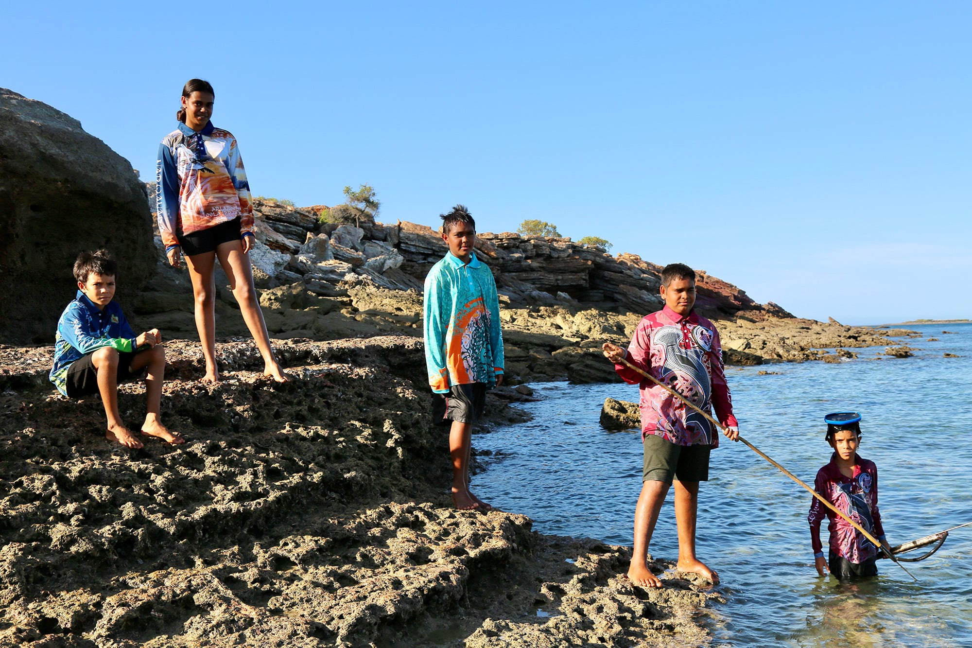 Bardi kids spearing from rocks wearing Ardi'ol designed fishing shirts